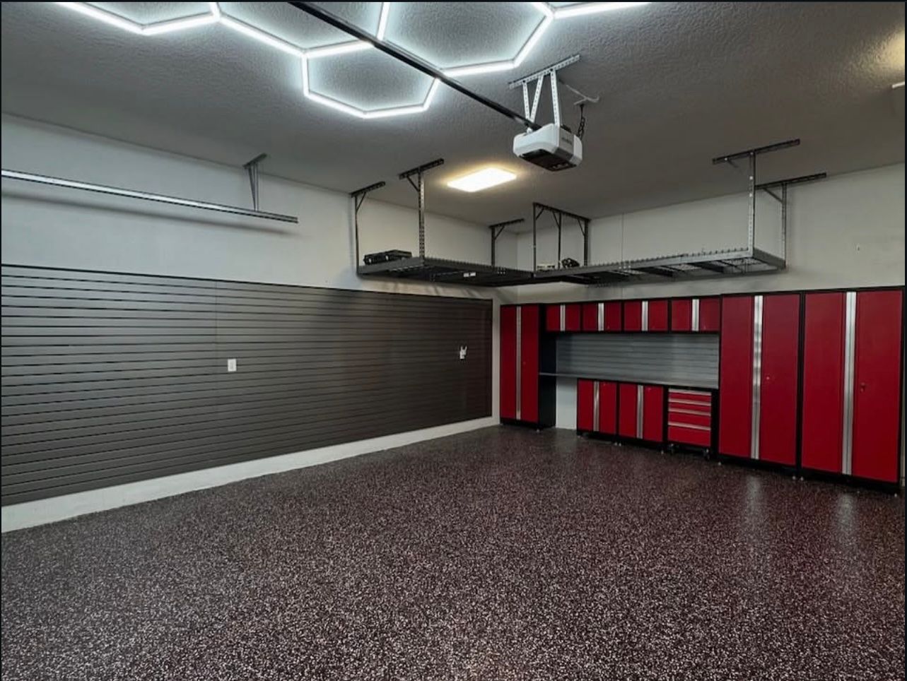 Hex garage lighting with overhead storage racks and red garage cabinets